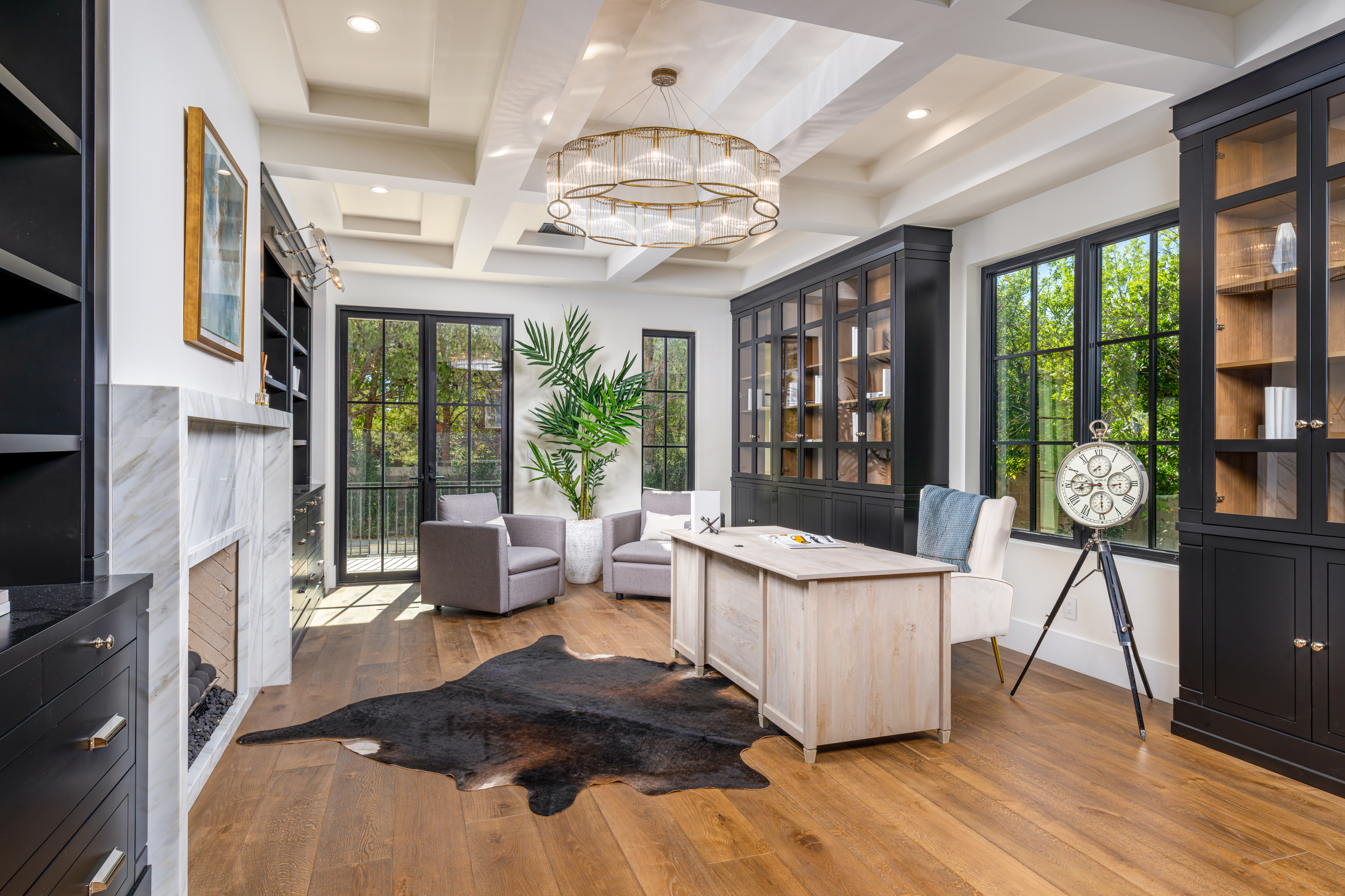Office at a Stately Mediterranean revival home in Las Vegas (8833 GL) — exposed wood ceiling beams, brass pendant lanterns, cream sofas, dark coffee tables.