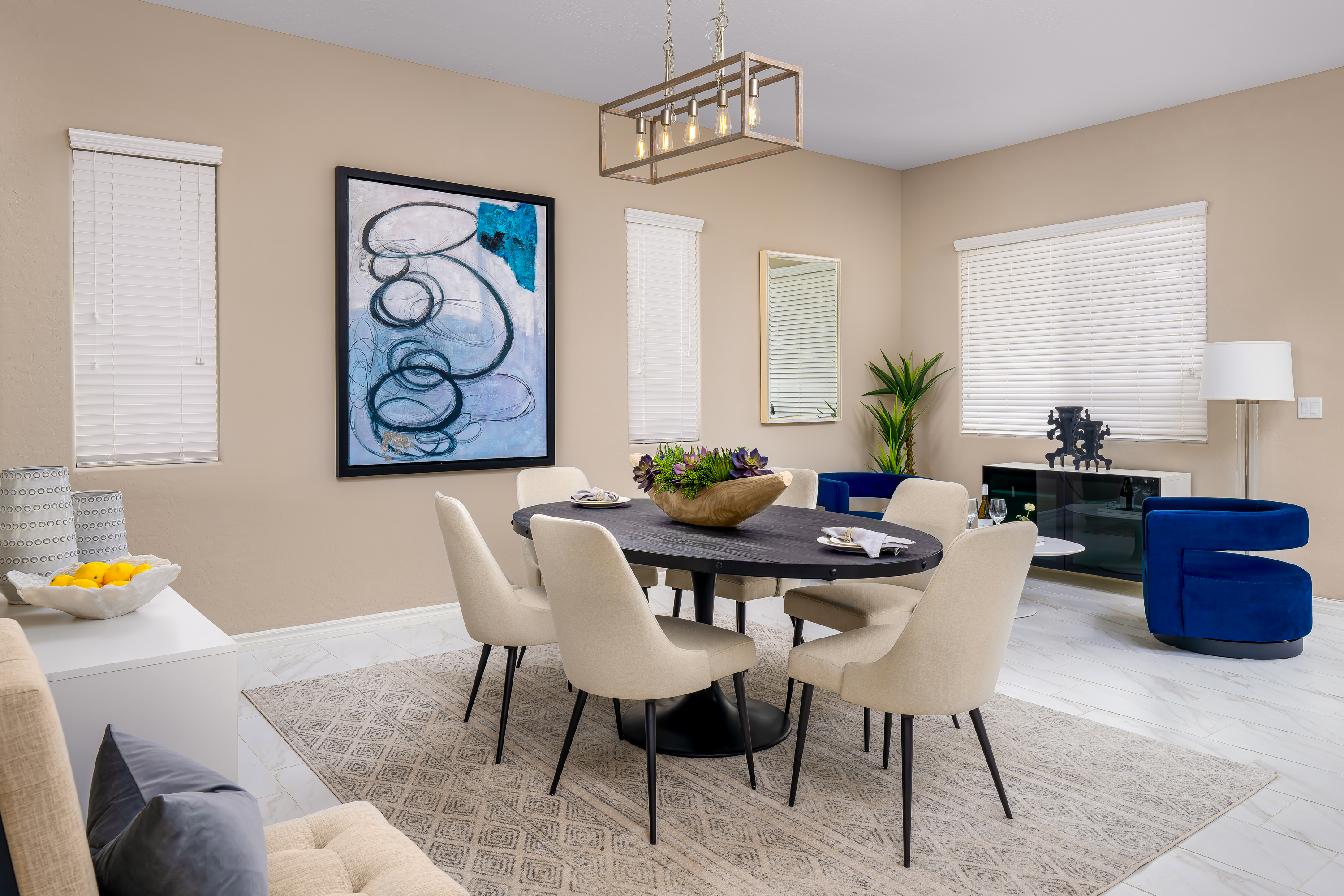 Living Room at a Stately contemporary Moroccan-influenced home in Las Vegas (2818 PSA) — navy velvet chairs, geometric blue-white art, gold accents, marble tile.