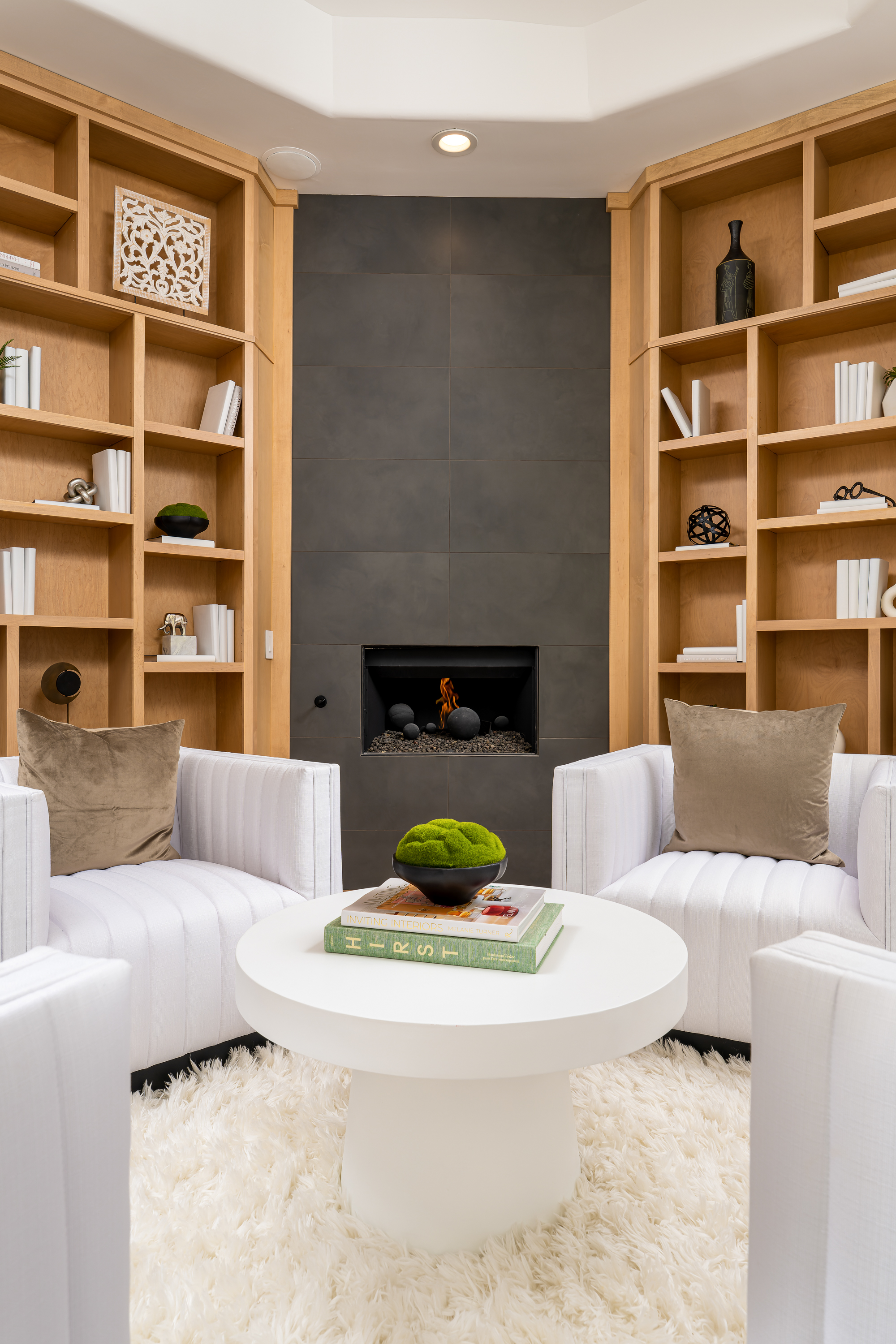 Library at a Stately library sitting room home in Las Vegas (9 YC) — Sputnik chandelier, wood ladder bookcase, channel-tufted swivel chairs, shag rug.